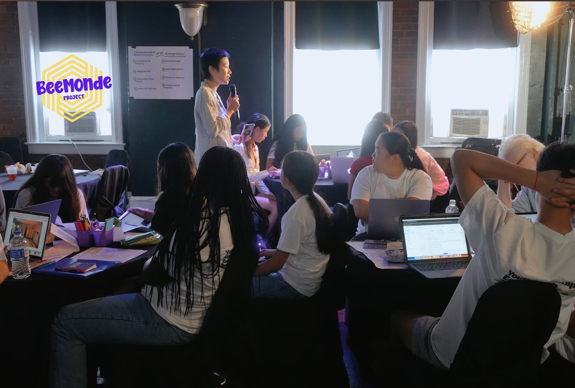 A program leader speaking to a small group of students during a workshop session
