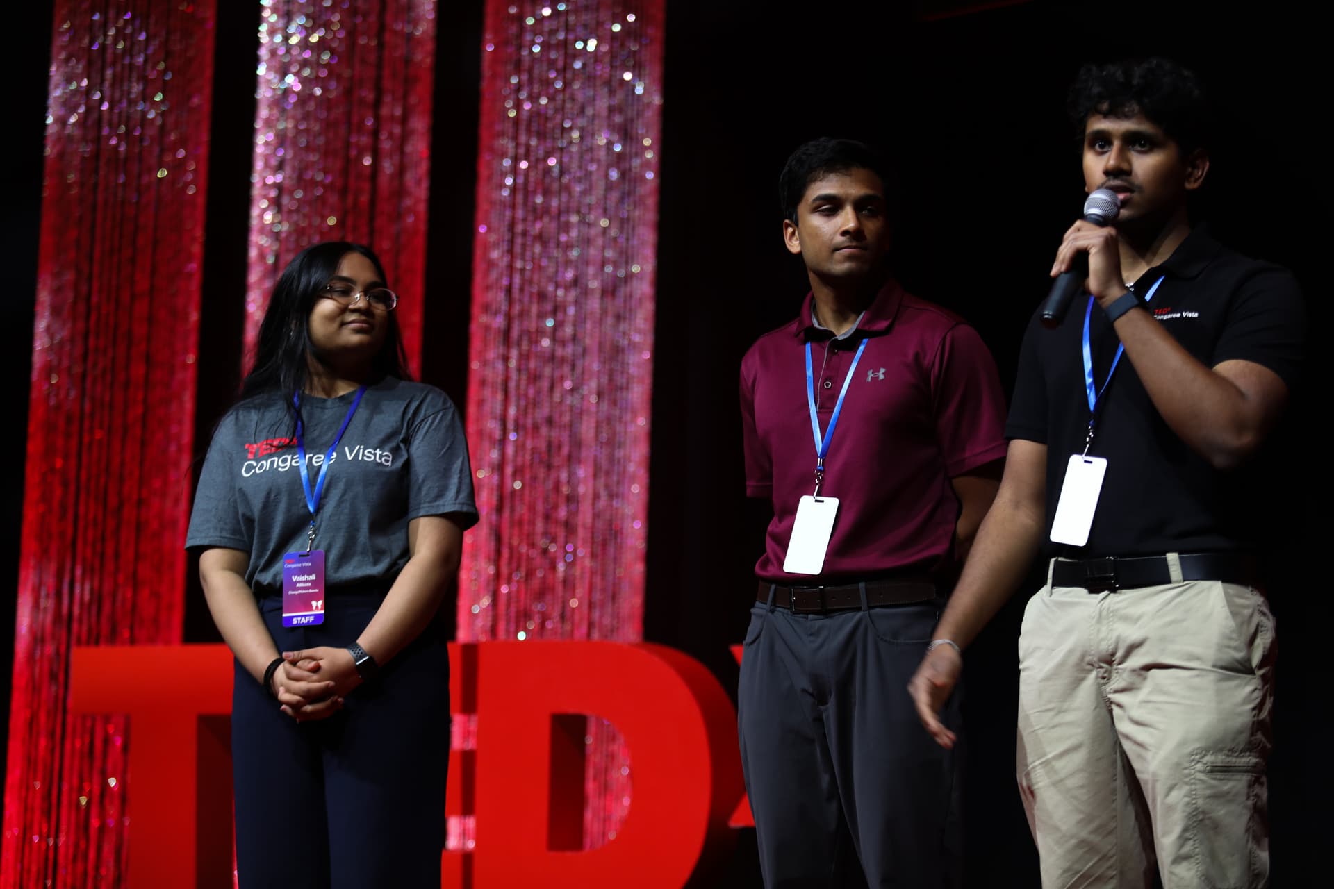 Inspire Columbia team members on stage, one speaking into a microphone